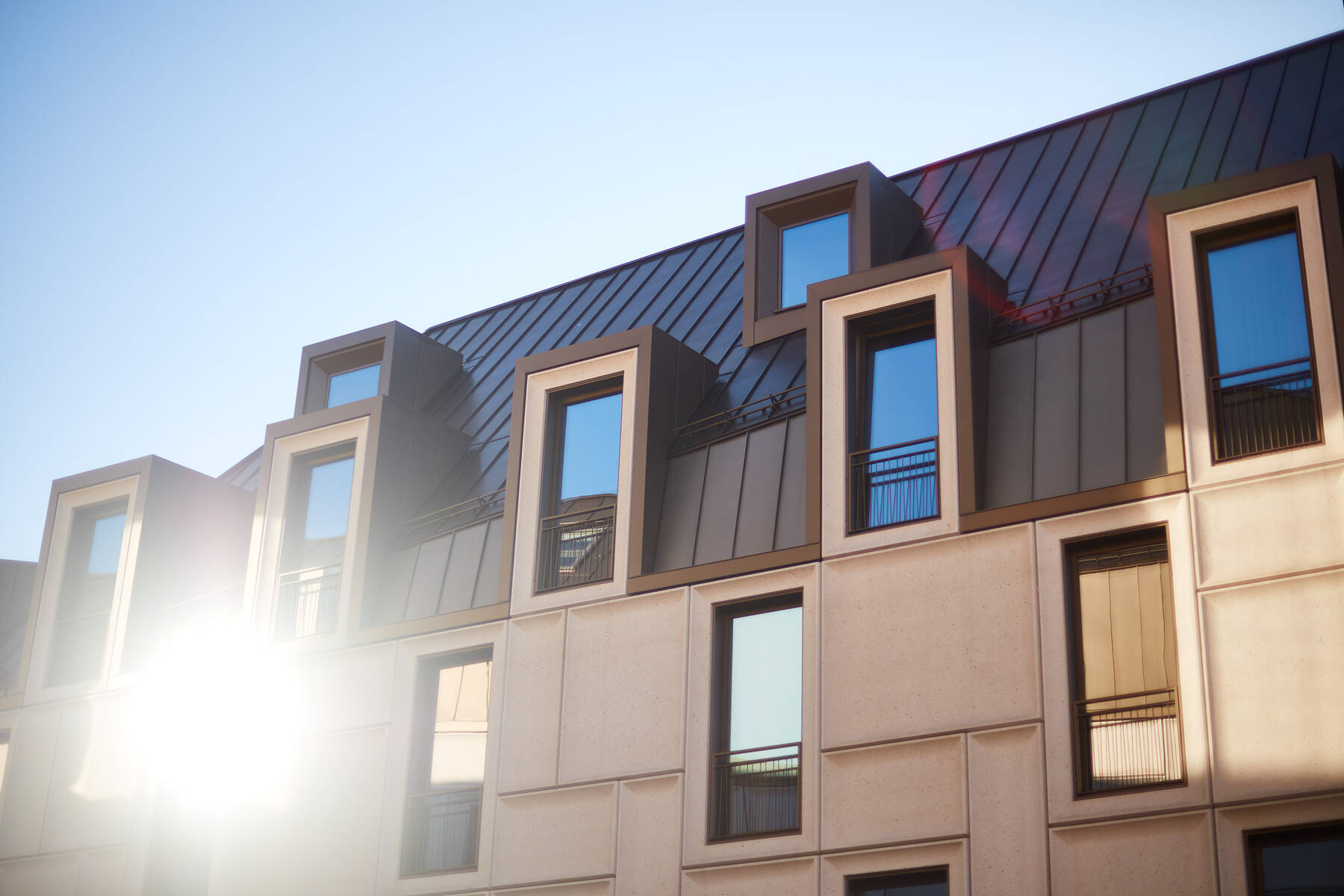 Fassadendetail des Augustinerhofs in Nürnberg mit modernen Isolar Glasflächen und Lichtreflexion in der Morgensonne.