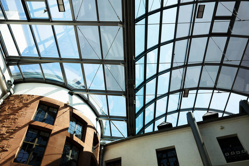 Blick nach oben in die Stahl-Glas-Konstruktion des Museumsdachs, die ohne störende Stützen den großen Innenhof überspannt.