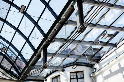 Weitwinkelaufnahme des lichtdurchfluteten Innenhofs im Historischen Museum Speyer unter der filigranen ISOLAR Glasdachkonstruktion.